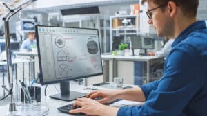 Man at computer designing a custom Wire Mesh basket